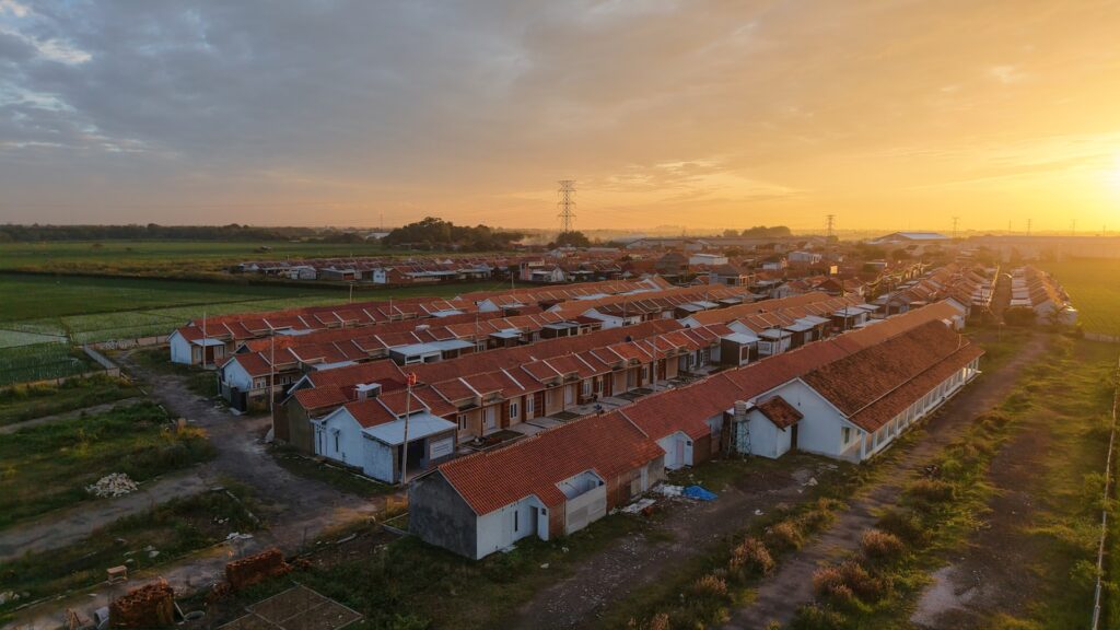 A bird's eye view of a farm with a sunset in the background