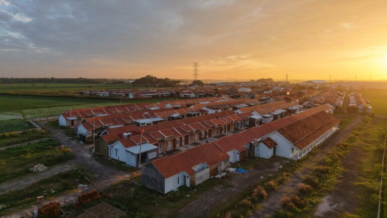 A bird's eye view of a farm with a sunset in the background